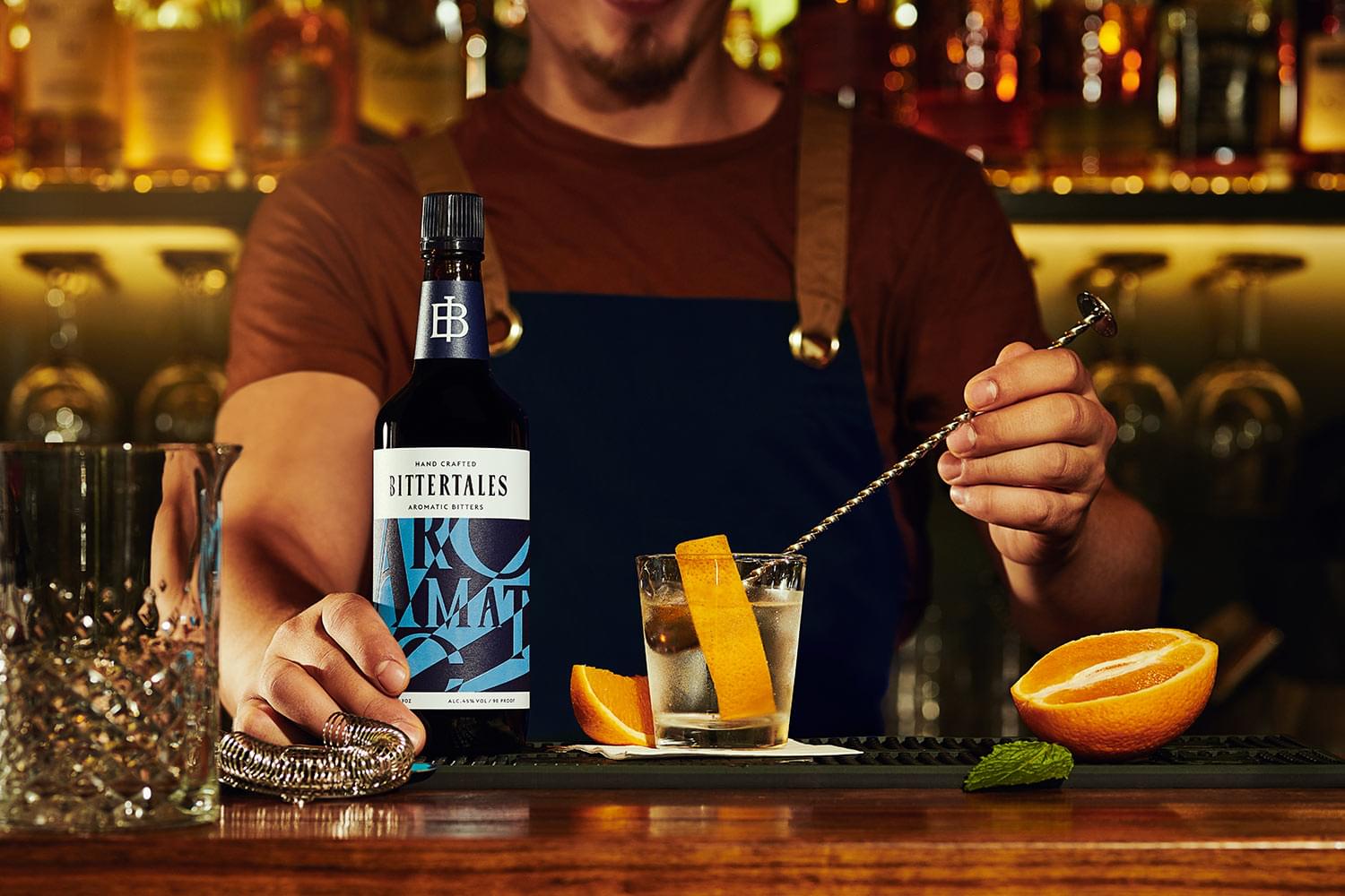 BITTERTALES bitters bottle on a bar next to a cocktail