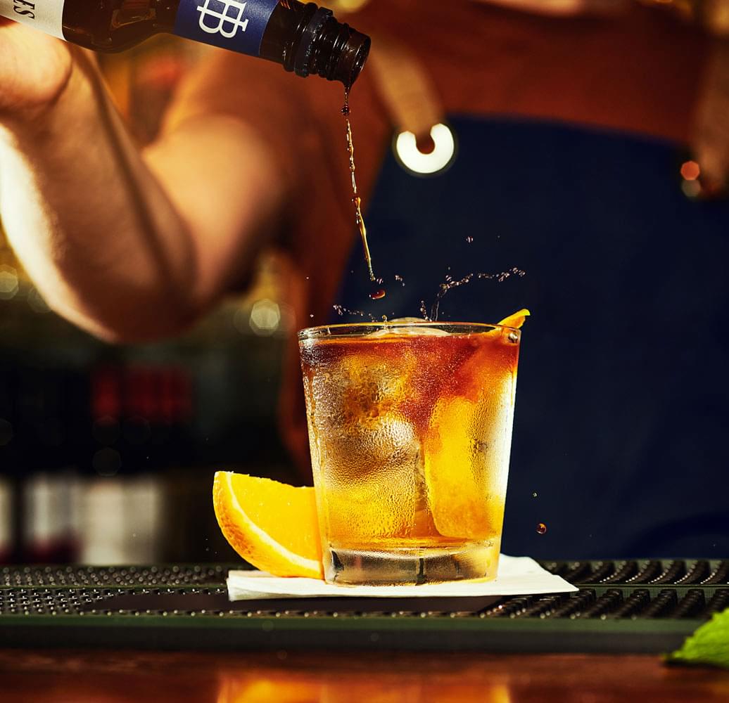 Dashes of bitters flavoring a cocktail